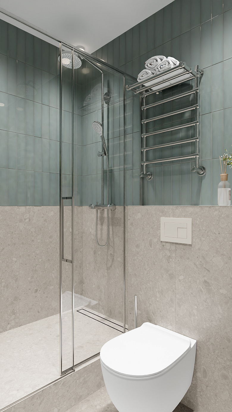 фото:Современная ванная с душевой в минималистичном стиле: сочетание серо-бежевой фактурной плитки внизу и спокойной бирюзовой кафельной кладки вверху. Центральные элементы — стеклянная душевая кабина с хромированной фурнитурой и подвесной унитаз с лаконичной кнопкой смыва. Акценты: стильный металлический полотенцесушитель с аккуратно сложенными полотенцами, небольшая ваза с сухоцветами. Чистые линии, нейтральная палитра и функциональные детали создают ощущение свежести и порядка