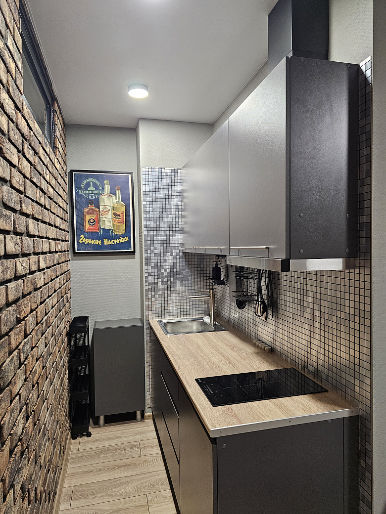 фото:Слева от входной двери (справа на фото) гардеробная с гладильной доской, справа (дверь около картины с пельменями) ванная комната. Кухня поделега на 2 зоны, справа зона готовки, слева зона столовой с телевизором, в кирпичной стене две двери - вход в две раздельные спальни