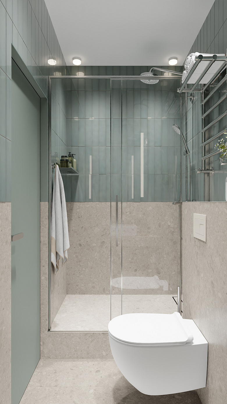 фото:Современная ванная в минималистичном стиле: сочетание светло-серой фактурной плитки на стенах и полу с бирюзовой кафельной кладкой в зоне душа. Центральные элементы — стеклянная душевая кабина с хромированной фурнитурой, подвесной унитаз с лаконичной кнопкой смыва. Функциональные детали: металлический полотенцесушитель, накладная полка для банных принадлежностей, точечное потолочное освещение. Чистые линии, нейтральная палитра и продуманная эргономика создают ощущение простора и уюта