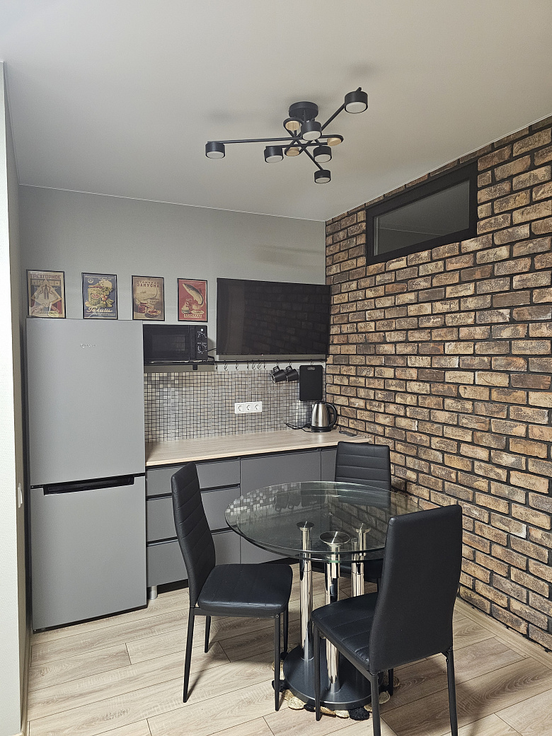 фото:Слева от входной двери (справа на фото) гардеробная с гладильной доской, справа (дверь около картины с пельменями) ванная комната. Кухня поделега на 2 зоны, справа зона готовки, слева зона столовой с телевизором, в кирпичной стене две двери - вход в две раздельные спальни