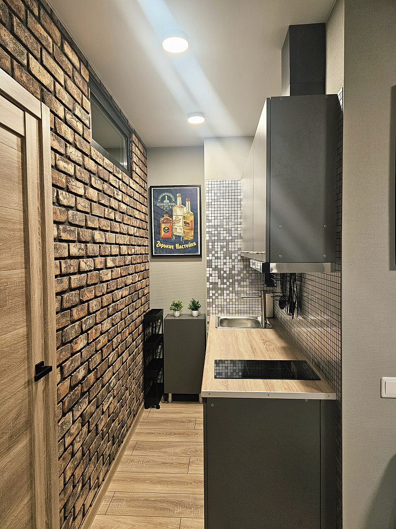 фото:Слева от входной двери (справа на фото) гардеробная с гладильной доской, справа (дверь около картины с пельменями) ванная комната. Кухня поделега на 2 зоны, справа зона готовки, слева зона столовой с телевизором, в кирпичной стене две двери - вход в две раздельные спальни