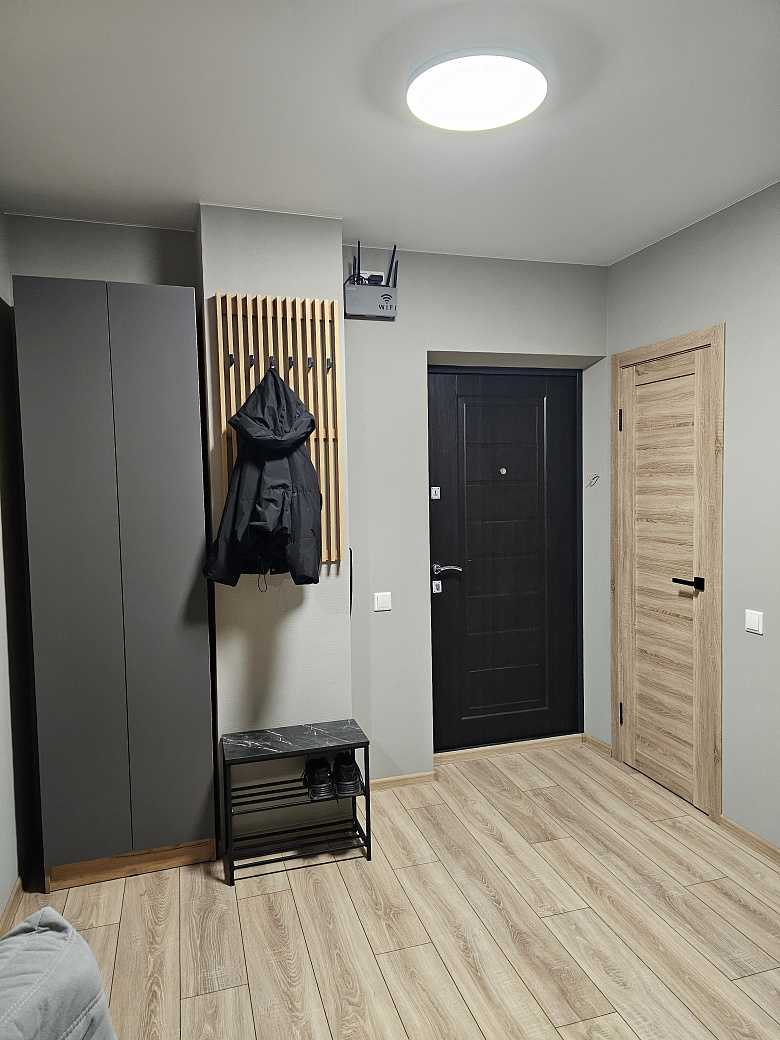 фото:Слева от входной двери (справа на фото) гардеробная с гладильной доской, справа (дверь около картины с пельменями) ванная комната. Кухня поделега на 2 зоны, справа зона готовки, слева зона столовой с телевизором, в кирпичной стене две двери - вход в две раздельные спальни