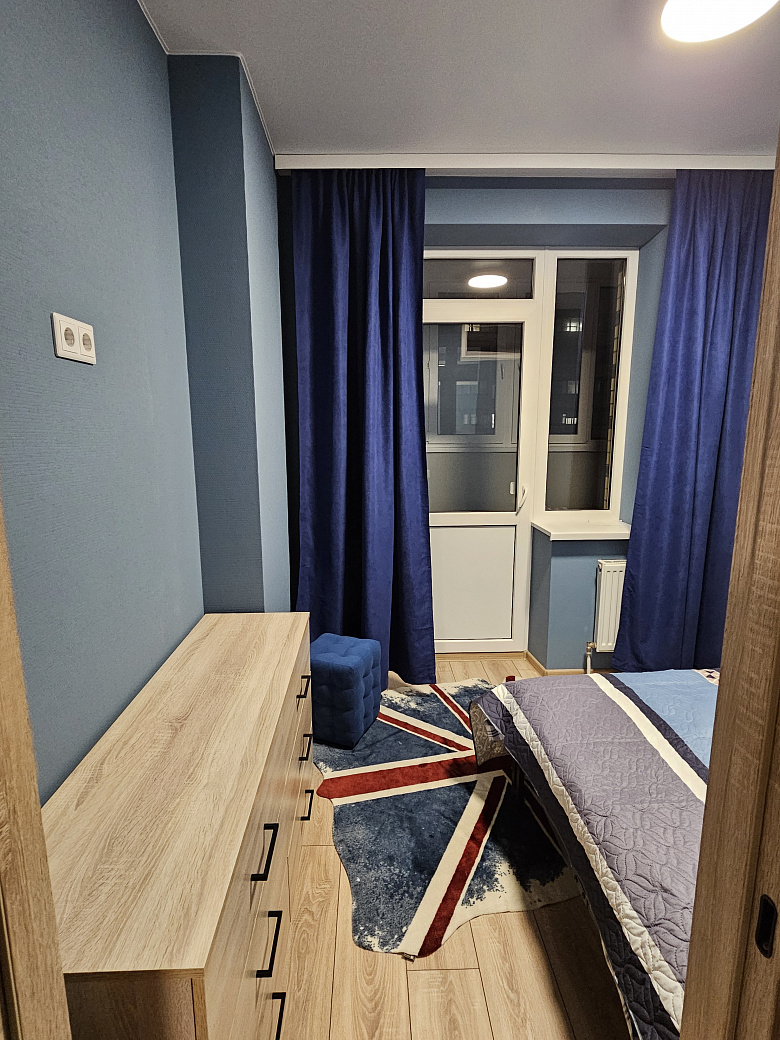 фото:Кровать шириной 140 см, лоджия шириной 130 см, утеплена, там стоит рабочий стол 120 см шириной, шкафы навесные над столом для хранения и стул