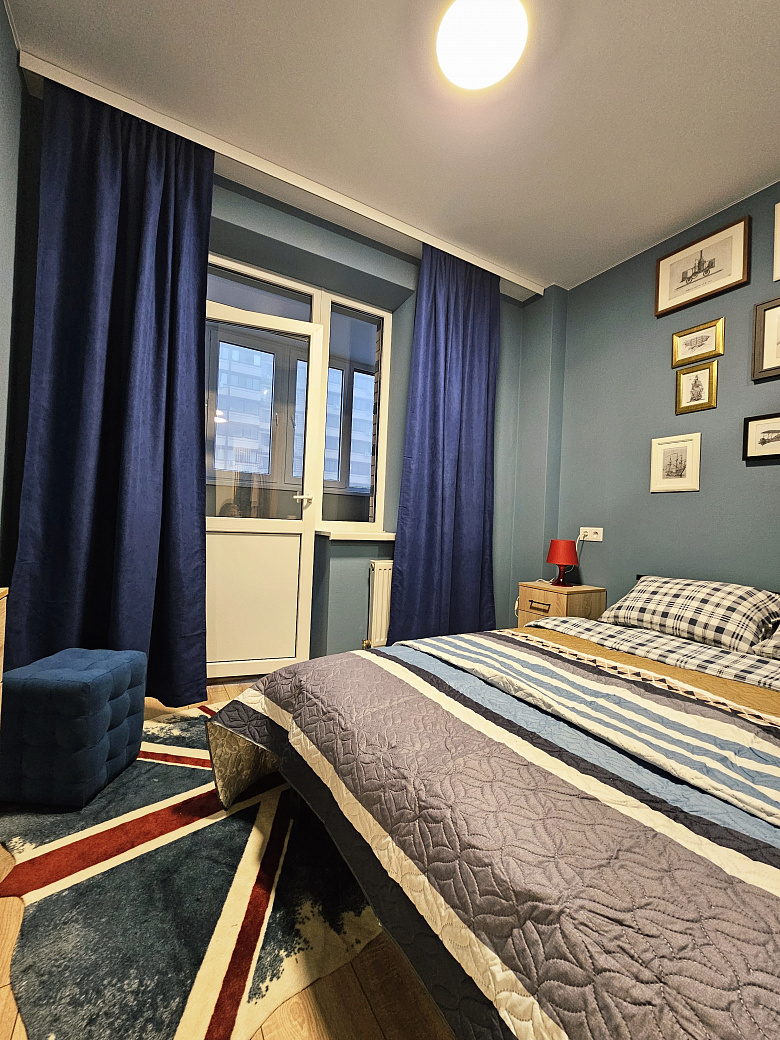 фото:Кровать шириной 140 см, лоджия шириной 130 см, утеплена, там стоит рабочий стол 120 см шириной, шкафы навесные над столом для хранения и стул