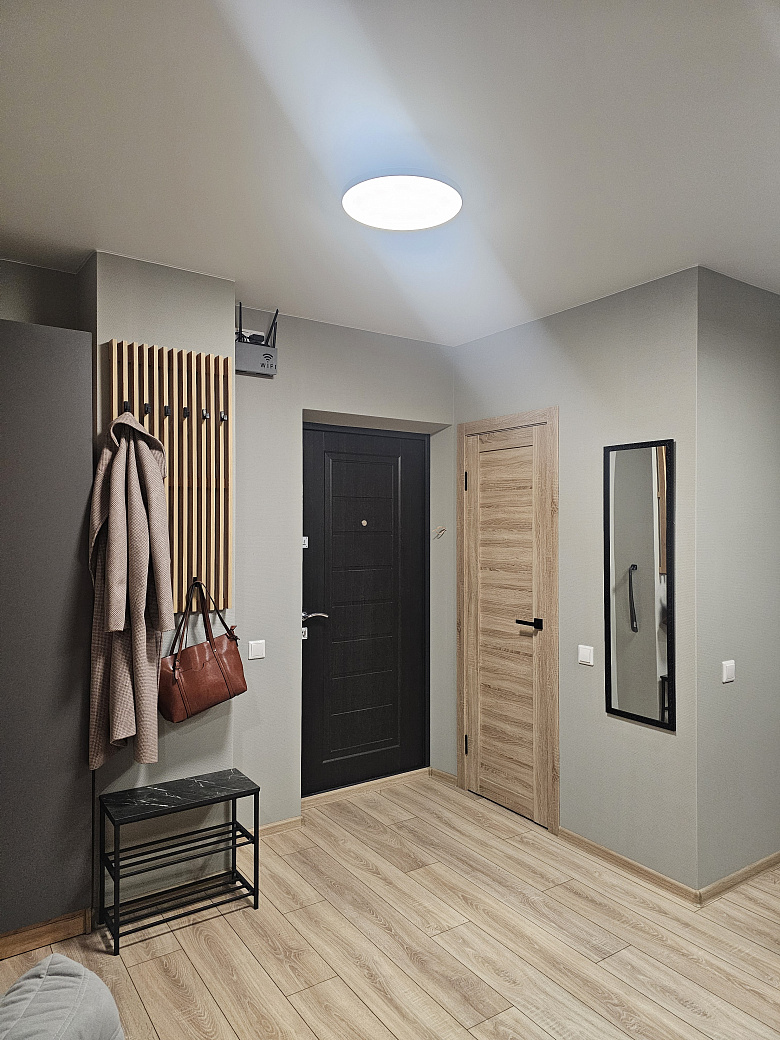 фото:Слева от входной двери (справа на фото) гардеробная с гладильной доской, справа (дверь около картины с пельменями) ванная комната. Кухня поделега на 2 зоны, справа зона готовки, слева зона столовой с телевизором, в кирпичной стене две двери - вход в две раздельные спальни