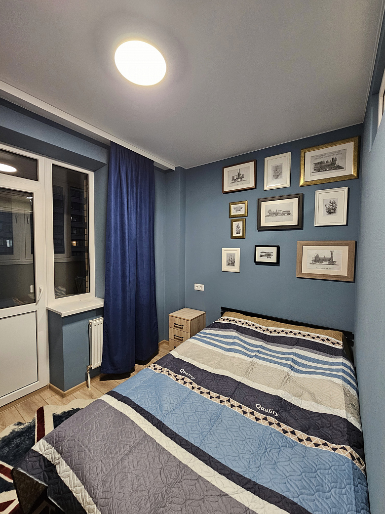 фото:Кровать шириной 140 см, лоджия шириной 130 см, утеплена, там стоит рабочий стол 120 см шириной, шкафы навесные над столом для хранения и стул